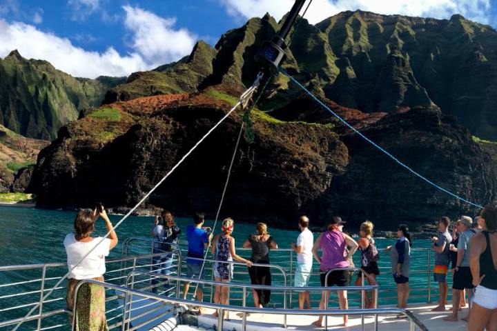 a group of people in a boat on the side of a mountain