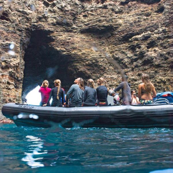 a group of people riding on the back of a boat in the water