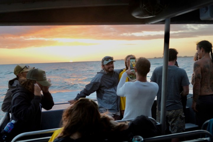 a group of people standing next to a body of water