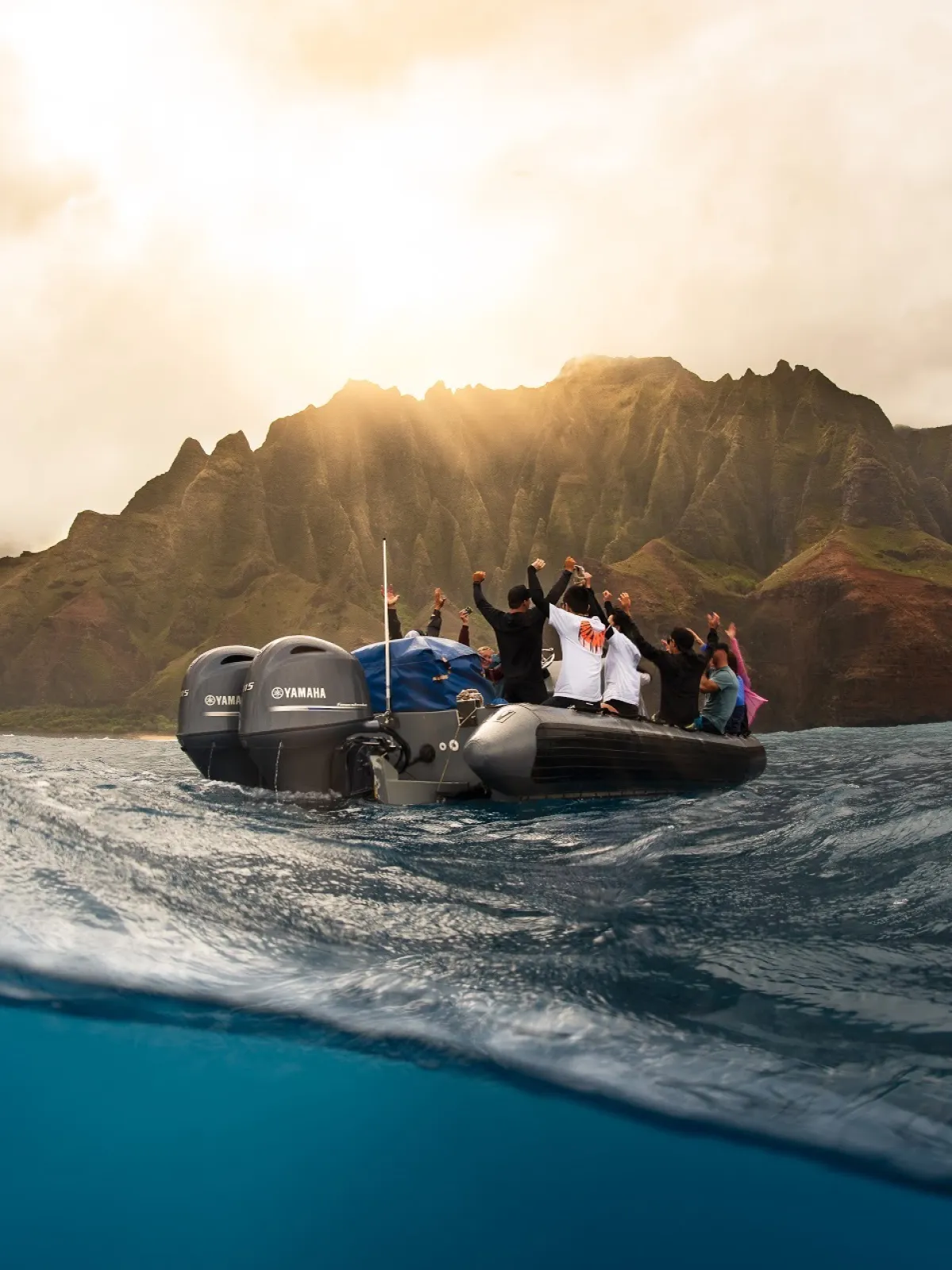 a man riding on the back of a boat next to a mountain
