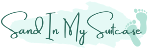 Logo with 'Sand In My Suitcase' and two teal footprints on a light teal background.